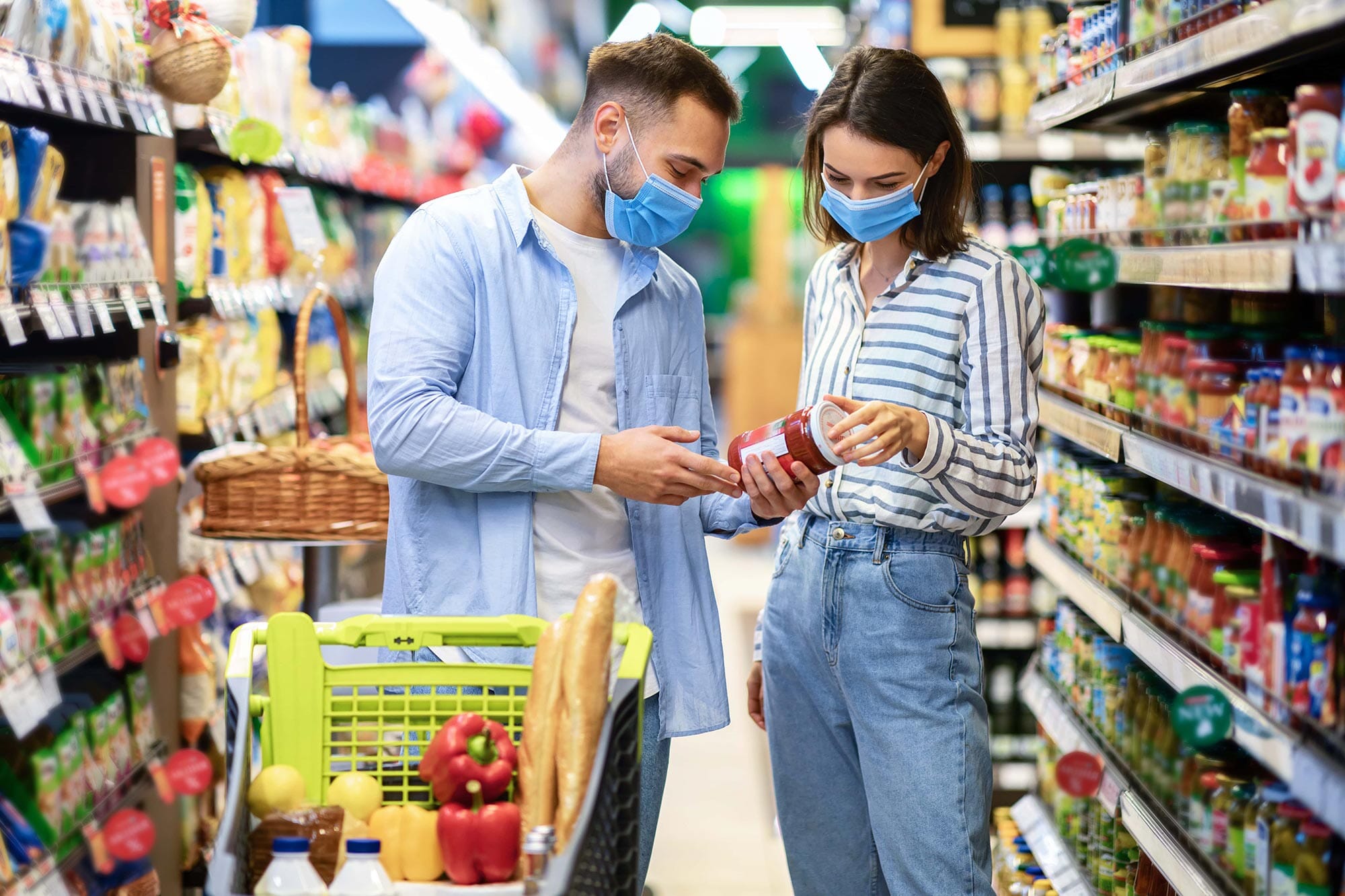 young-couple-in-protective-masks-shopping-in-super-KPQ4NFC-min